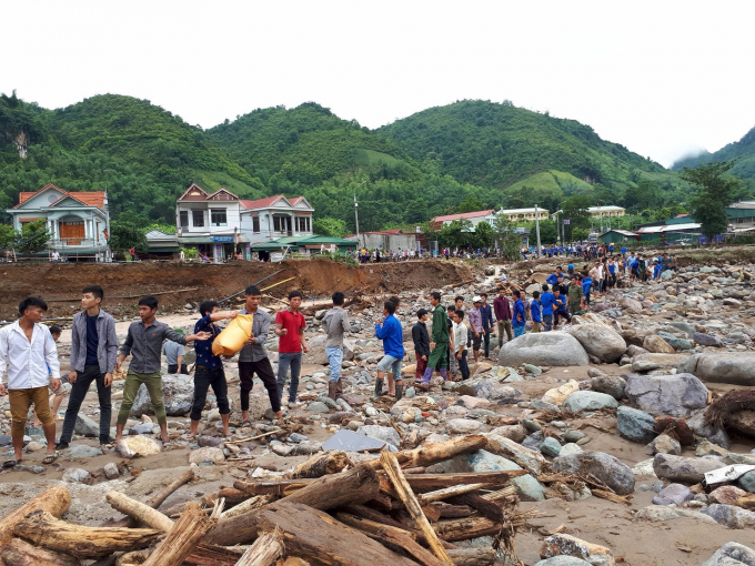 Thanh ni&ecirc;n xếp h&agrave;ng d&agrave;i để vận chuyển gạo, nước vượt suối&nbsp;Ảnh Thanh Trang.