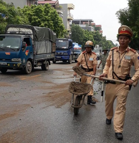 Lực lượng CSGT c&oacute; mặt tại hiện trường xử l&yacute; vết dầu do xe tải l&agrave;m rơi.