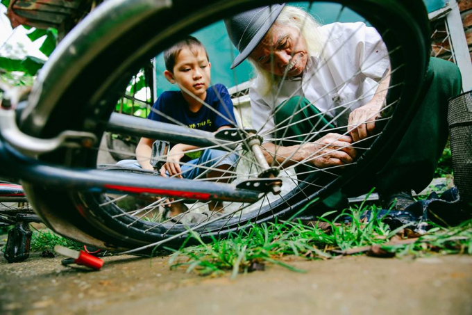 &Ocirc;ng Đỗ Quang Mạc tỉ mẩn sửa lại chiếc xe cho em nhỏ.
