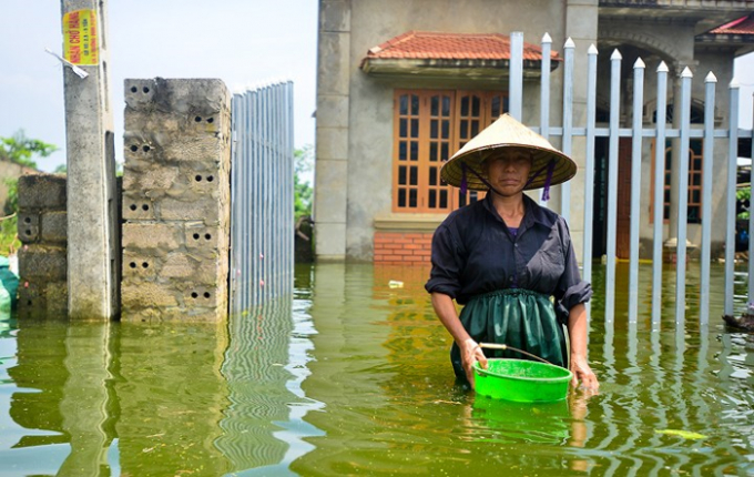 C&ocirc; Nguyễn Thị M&ugrave;i đứng trước ng&ocirc;i nh&agrave; đ&atilde; ngập ng&oacute;t 10 ng&agrave;y. C&ocirc; M&ugrave;i cho biết, so với những ng&agrave;y trước th&igrave; nước đ&atilde; r&uacute;t đi khoảng 30-40cm. Hiện to&agrave;n bộ khu vực th&ocirc;n Nam H&agrave;i đều đang thiếu nước sạch, người d&acirc;n phải mua nước b&igrave;nh 20L về để d&ugrave;ng nhưng kh&ocirc;ng đủ so với nhu cầu d&ugrave; l&agrave; tối thiểu.