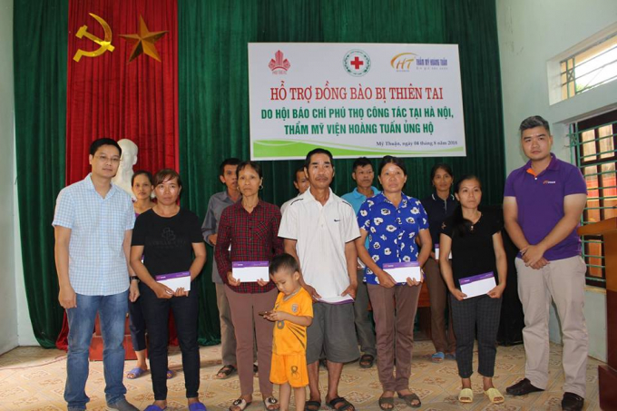 &Ocirc;ng Ho&agrave;ng Minh Th&agrave;nh, Ph&oacute; tổng bi&ecirc;n tập của tạp ch&iacute; Thương Hiệu v&agrave; Ph&aacute;p luật (ngo&agrave;i c&ugrave;ng b&ecirc;n tr&aacute;i) c&ugrave;ng &ocirc;ng B&ugrave;i Mạnh Anh, đại diện thẩm mỹ viện Ho&agrave;ng Tuấn trao qu&agrave; cho b&agrave; con v&ugrave;ng lũ thuộc x&atilde; Mỹ Thuận.