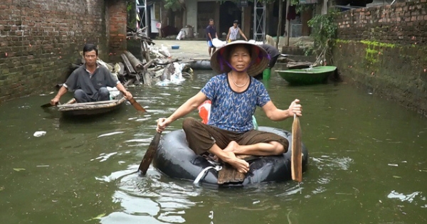 Hà Nội: Người dân vùng ngập chèo thuyền nhận quà từ thiện