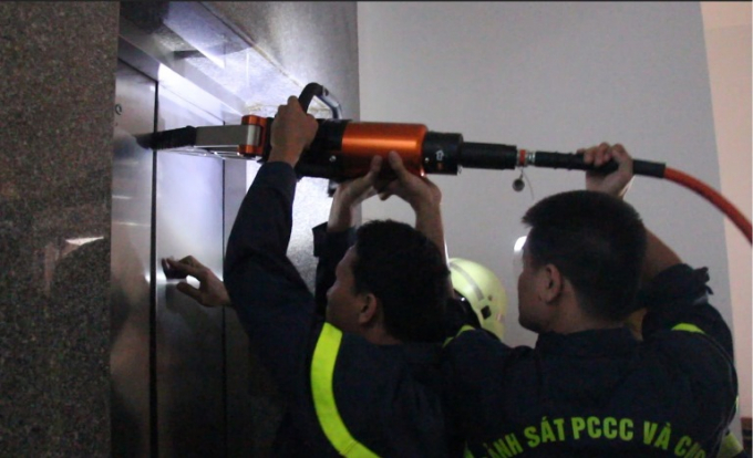 Cảnh s&aacute;t PCCC d&ugrave;ng thiết bị banh thuỷ lực mở cửa thang m&aacute;y cứu nạn nh&acirc;n. Ảnh: PCCC ĐN.