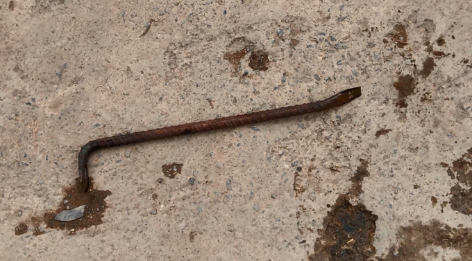 X&agrave; beng bằng sắt được hai thanh ni&ecirc;n d&ugrave;ng để cậy nắp cống.