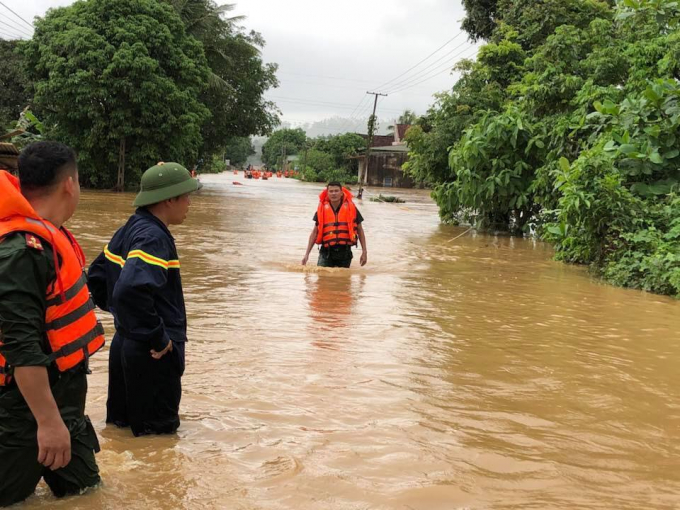 Lực lượng c&ocirc;ng an huyện Q&ugrave;y Hợp dầm m&igrave;nh trong nước lũ di dời d&acirc;n.