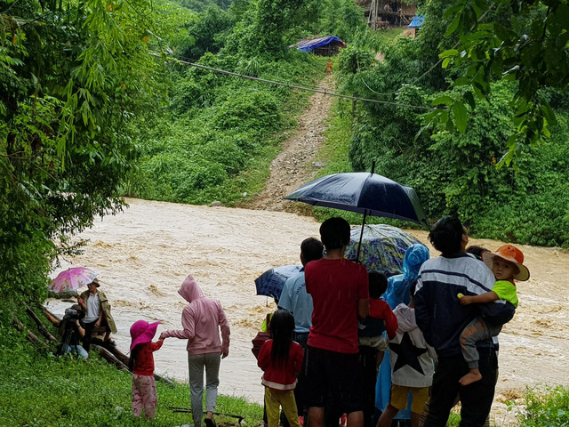 Hơn 300 người d&acirc;n tại đ&acirc;y bị mắc kẹt do nước lũ l&ecirc;n cao. Trường học, diện t&iacute;ch đất sản xuất của bản đều ở ph&iacute;a b&ecirc;n kia khe Nậm Hỷ. Chỉ c&aacute;ch đường quốc lộ một con khe, thế nhưng, b&agrave; con d&acirc;n bản kh&ocirc;ng thể qua lại, đ&agrave;nh bất lực đứng nh&igrave;n d&ograve;ng nước hung dữ.