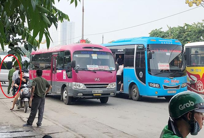 Xe kh&aacute;ch d&agrave;n h&agrave;ng ngang bắt kh&aacute;ch tr&ecirc;n đường nhưng một c&aacute;n bộ c&ocirc;ng an (v&ograve;ng tr&ograve;n) l&agrave;m việc tại cổng bến Gi&aacute;p B&aacute;t s&aacute;ng 20/8 chỉ đứng nh&igrave;n.