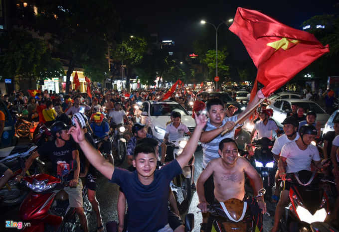 Tại khu vực phố Đinh Ti&ecirc;n Ho&agrave;ng (Ho&agrave;n Kiếm, H&agrave; Nội), h&agrave;ng chục ngh&igrave;n người h&acirc;m mộ tr&agrave;n xuống đường phất cờ, h&ograve; h&eacute;t mừng chiến thắng.
