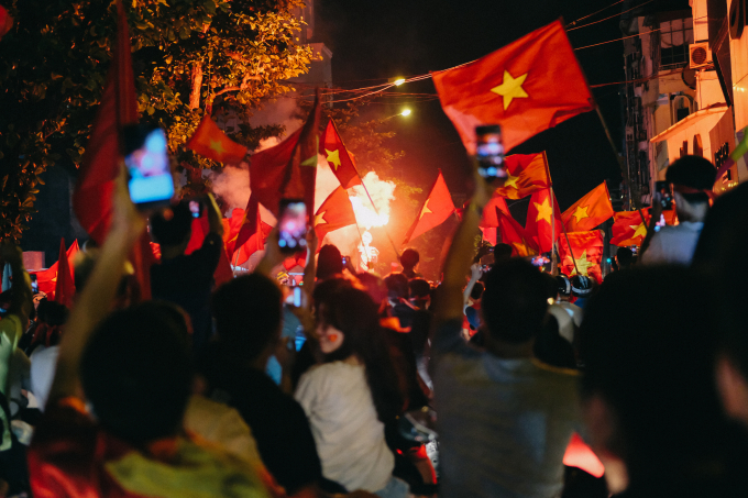 Tại phố Nguyễn Th&aacute;i Học (H&agrave; Nội), một tốp bạn trẻ đốt ph&aacute;o s&aacute;ng dẫn đầu đo&agrave;n xe m&aacute;y tiến về ph&iacute;a Hồ Gươm để ăn mừng.