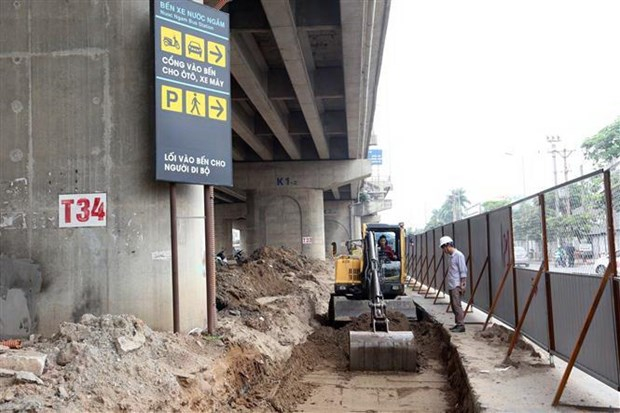 Thi công khu vực mở rộng lối vào đường Pháp Vân. Ảnh: Huy Hùng/TTXVN.