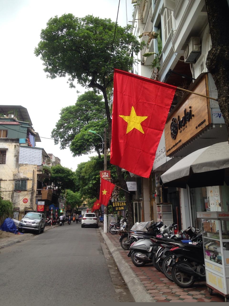 M&agrave;u cờ đỏ rợp cả vỉa h&egrave; đường phố H&agrave; Nội.