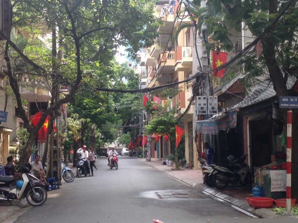 Cũng như những con đường kh&aacute;c của Thủ đ&ocirc;, đường Xu&acirc;n La cũng đang kho&aacute;c l&ecirc;n m&igrave;nh một diện mạo mới với những l&aacute; cờ đỏ sao v&agrave;ng được treo dọc đường.