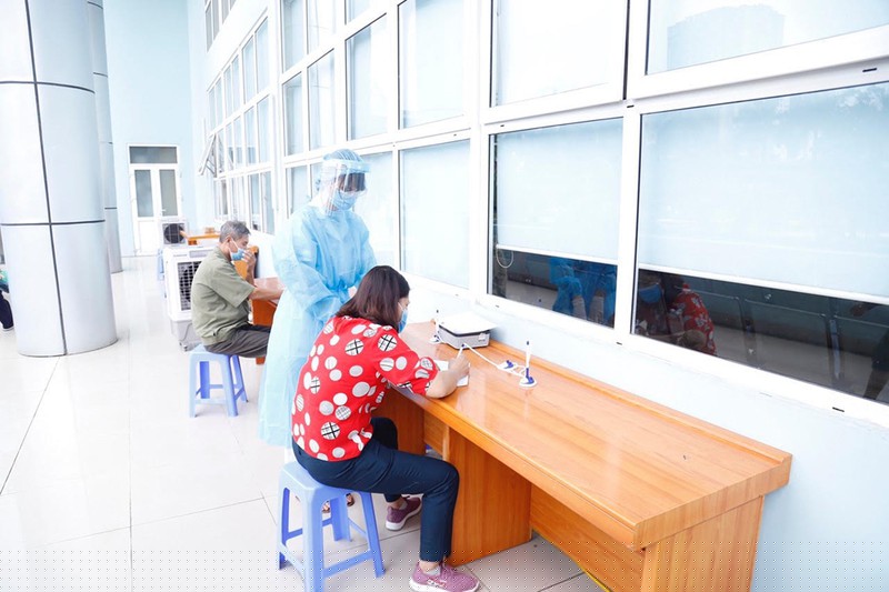 Nhân viên y tế hướng dẫn người dân khai báo thông tin trước khi vào bệnh viện.