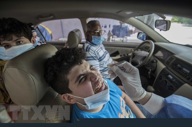Nhân viên y tế lấy mẫu xét nghiệm COVID-19 tại Cairo, Ai Cập. (Ảnh: AFP/TTXVN)