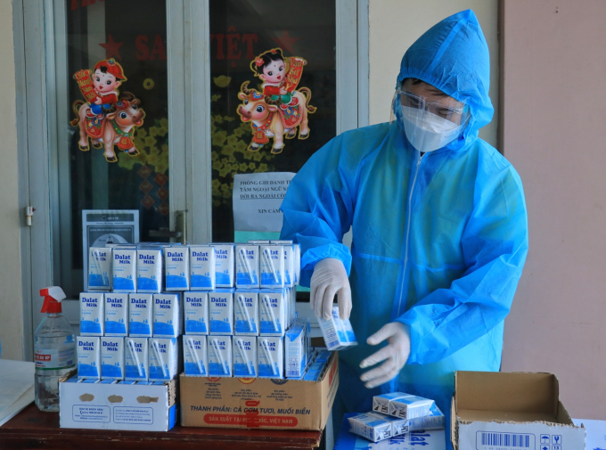 Một người làm việc tại Siêu thị 0 đồng đang khui những phần sữa để tặng cho bà con sau khi mua hàng tại đây. “Bình thường chúng tôi sẽ tặng 2 hộp sữa tươi Dalatmilk (do Tập đoàn TH tài trợ) cho người đến mua. Nhưng cũng có những trường hợp người ta xin thêm, những người mang theo con nhỏ chúng tôi có thể tặng thêm 1, 2 lốc”, chị Trần Thị Tâm phụ trách siêu thị cho biết.