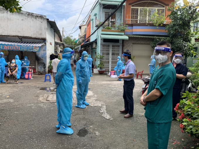 PGS.TS Đoàn Quốc Hưng - Phó Hiệu trưởng, Quyền điều hành Trường ĐH Y Hà Nội (Áo sơ mi ngắn tay) đang đồng hành với cán bộ nhà trường phối hợp cùng Y tế địa phương lấy mẫu xét nghiệm Covid tại khu dân cư vùng nguy cơ ở Quận 6 TP Hồ Chí Minh vào sáng ngày 27/8.