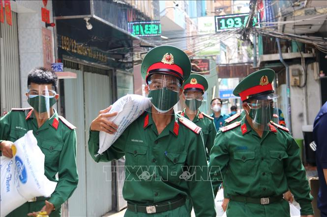 Bộ đội Quân khu 7 đưa lượng thực, thực phẩm đến tận nhà người lao động nghèo ở những nơi bị phong tỏa. Ảnh: Thanh Vũ/TTXVN