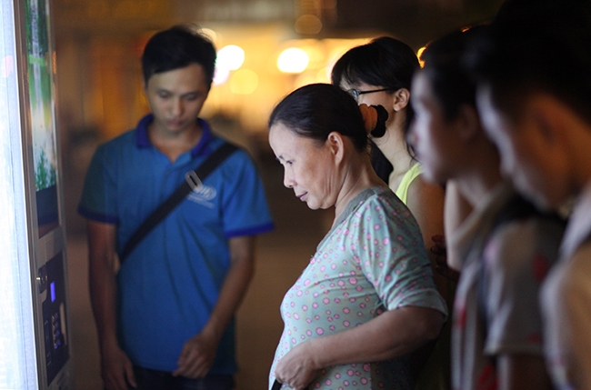 Một số người d&acirc;n trải nghiệm một số dịch vụ mới lạ như quầy mua b&aacute;n nước tự động.