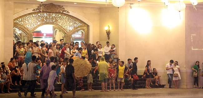 Rất đ&ocirc;ng người d&acirc;n tr&uacute; mưa tại Trung t&acirc;m thương mại Tr&agrave;ng Tiền.