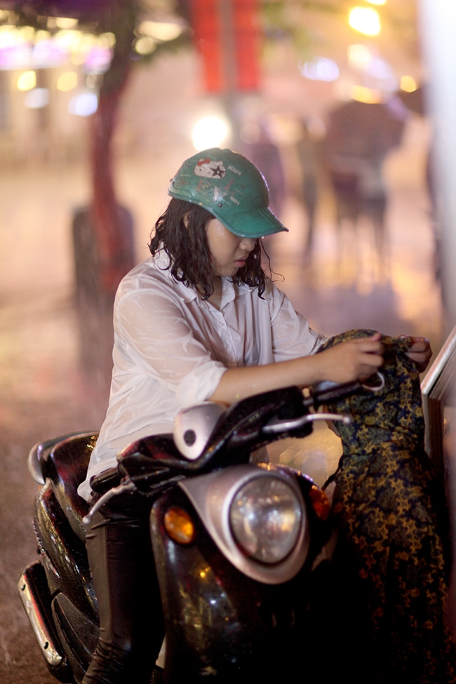 Cố đi v&agrave;o phố đi bộ nhưng gặp mưa lớn n&ecirc;n hai mẹ con phải tr&uacute; tạm.