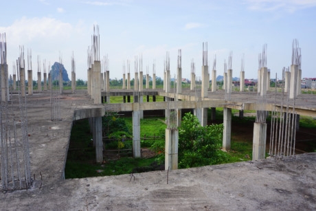 Cạnh nh&agrave; điều h&agrave;nh 9 tầng l&agrave; khu nh&agrave; chức năng đ&atilde; được đổ m&oacute;ng ki&ecirc;n cố với h&agrave;ng chục trụ cột xi măng, l&otilde;i th&eacute;p dang dở.