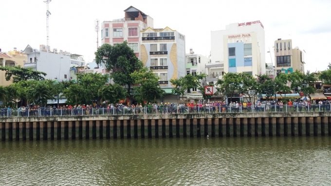 H&agrave;ng trăm người phơi nắng đứng dọc hai bờ k&ecirc;nh để theo d&otilde;i vụ việc.