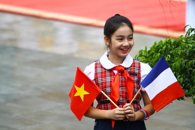 Thiếu nhi H&agrave; Nội với quốc kỳ hai nước ch&agrave;o đ&oacute;n Tổng thống Ph&aacute;p. (Ảnh:&nbsp;Nguyễn Kh&aacute;nh)