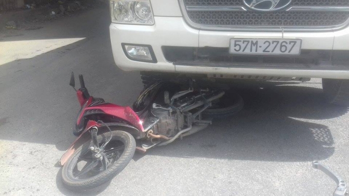 Chiếc xe m&aacute;y nằm dưới gầm xe ben.