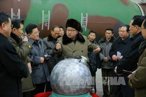 Nh&agrave; l&atilde;nh đạo Triều Ti&ecirc;n Kim Jong-un (giữa) trong một cuộc gặp với c&aacute;c nh&agrave; khoa học v&agrave; kỹ thu&acirc;̣t vi&ecirc;n trước m&ocirc; hình m&ocirc;̣t ph&acirc;̀n đ&acirc;̀u đạn hạt nh&acirc;n thu nhỏ ng&agrave;y 9/3. (Ảnh: Yonhap/TTXVN)