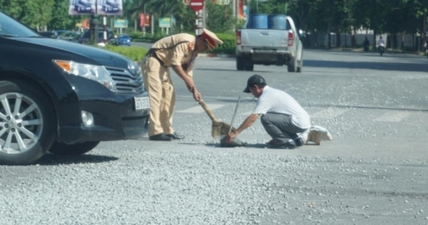 CSGT đội nắng quét đá dăm rơi trên đường