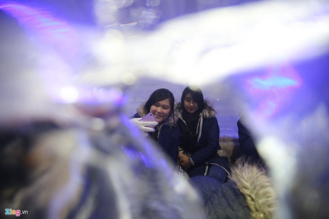 Hai bạn trẻ th&iacute;ch th&uacute; chụp ảnh kỷ niệm khi được mang &aacute;o kho&aacute;c giữa trời n&oacute;ng nực S&agrave;i G&ograve;n.