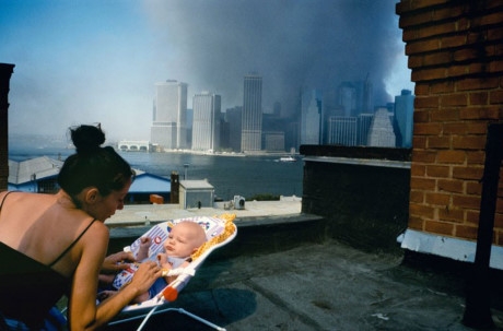 B&agrave; mẹ trẻ dỗ d&agrave;nh con nhỏ tr&ecirc;n tầng m&aacute;i của một ng&ocirc;i nh&agrave; ở Brooklyn trong khi những đ&aacute;m kh&oacute;i đen nghịt tại hiện trường&nbsp;vụ tấn c&ocirc;ng 11/9&nbsp;đang bao tr&ugrave;m bầu trời ở khu Hạ Manhattan.