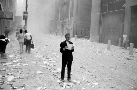 Người đ&agrave;n &ocirc;ng cho&aacute;ng v&aacute;ng đang cầm tr&ecirc;n tay một mảnh giấy bị hất văng từ hai t&ograve;a th&aacute;p.