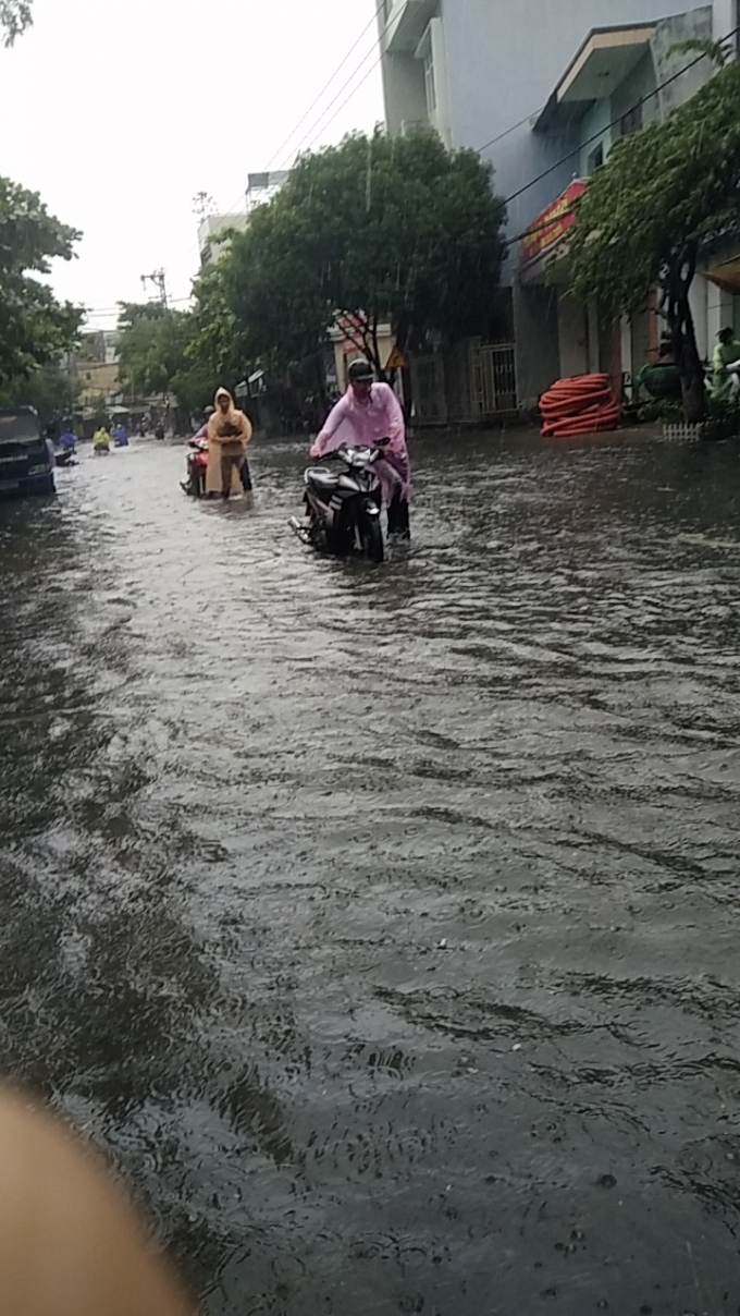 Nhiều người phải dắt xe lội trong biển nước.