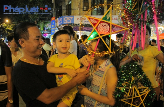 Một gia đ&igrave;nh chọn mua cho con nhỏ chiếc đ&egrave;n &ocirc;ng sao.