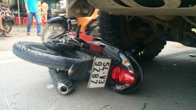 Chiếc xe m&aacute;y nằm dưới gầm xe ben.