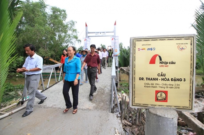 Những người d&acirc;n, em học sinh vui mừng đi tr&ecirc;n c&acirc;y cầu th&eacute;p d&acirc;y văng vừa kh&aacute;nh th&agrave;nh.