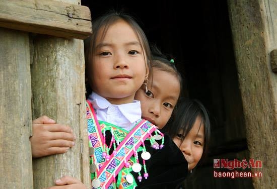 Sự e ngại trong tiếp x&uacute;c của cộng đồng người M&ocirc;ng v&agrave; cuộc sống mưu sinh h&agrave;ng ng&agrave;y khiến việc vận động học sinh đến lớp ở P&agrave; Khốm gặp kh&ocirc;ng &iacute;t kh&oacute; khăn. C&ocirc; gi&aacute;o Lưu chia sẻ: Để chuẩn bị cho mỗi buổi học, thầy c&ocirc; phải dậy sớm đến nh&agrave; để đ&oacute;n c&aacute;c ch&aacute;u đến trường. V&agrave;o m&ugrave;a gặt l&ugrave;a, m&ugrave;a h&aacute;i măng, nhiều trẻ theo cha mẹ l&ecirc;n n&uacute;i, thầy c&ocirc; lại phải bang đồi đi vận động trẻ đến lớp. Trong ảnh, bầy trẻ chờ c&ocirc; gi&aacute;o đến đ&oacute;n mới chịu l&ecirc;n lớp.