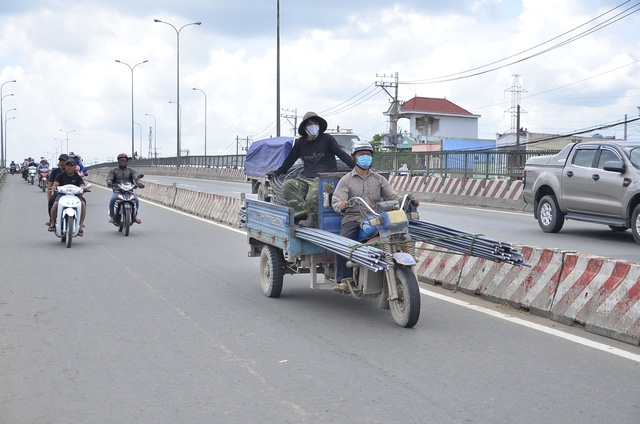 Một chiếc xe ba g&aacute;c chở th&eacute;p d&agrave;i ra ph&iacute;a trước rất nguy hiểm