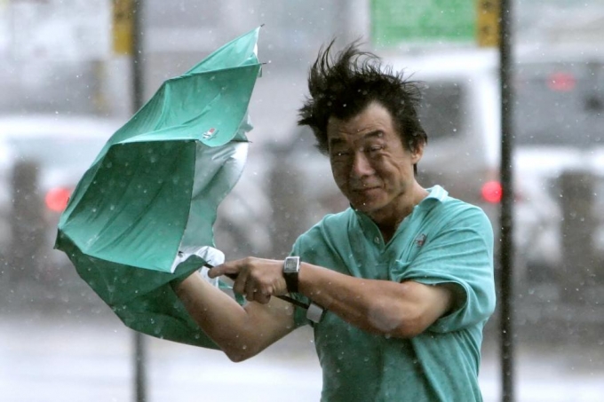 Một người d&acirc;n lấy &ocirc; để chắn gi&oacute; khi b&atilde;o&nbsp;Fung-Wong đổ bộ v&agrave;o Đ&agrave;i Loan năm 2008. (Ảnh: Reuters)