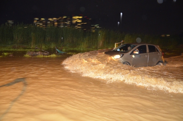 Một chiếc &ocirc; t&ocirc; chạy nhanh tạo s&oacute;ng tr&ecirc;n đường.