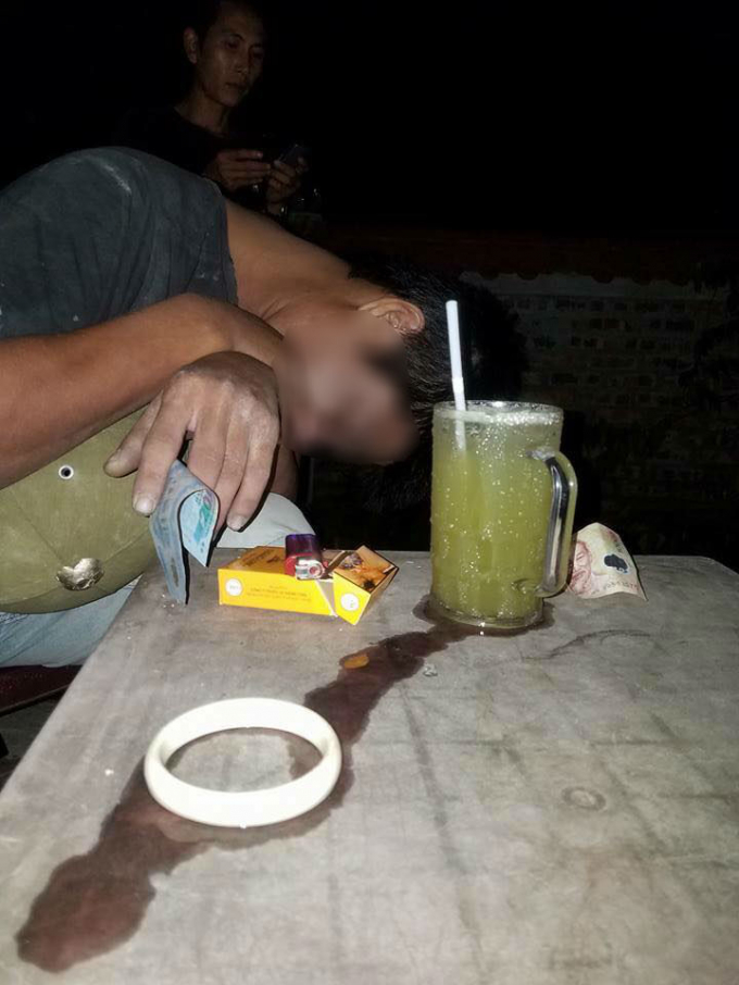 Người đ&agrave;n &ocirc;ng tử vong trong tư thế ngồi gục đầu tay vẫn cầm tiền (Ảnh: BĐCC)