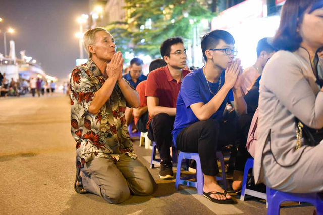 Người đ&agrave;n &ocirc;ng quỳ dưới l&ograve;ng đường, chắp tay hướng về ph&iacute;a ch&ugrave;a h&agrave;nh lễ.