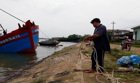 Một người d&acirc;n đưa t&agrave;u v&agrave;o nơi neo đậu.