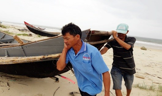 Người d&acirc;n khẩn trương đưa thuyền l&ecirc;n bờ.