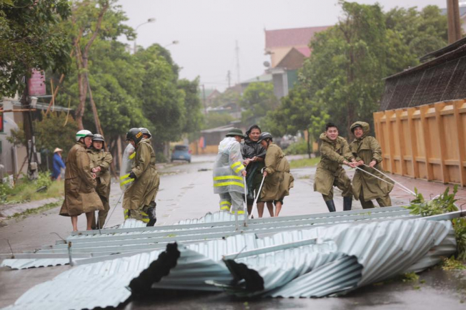 Lực lượng chức năng đang thu gom hậu quả sau b&atilde;o.