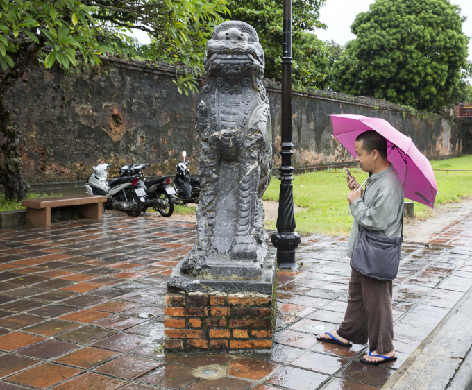 Trong mưa du kh&aacute;ch vẫn chụp ảnh lưu niệm hoặc ghi ch&eacute;p cổ vật trong khu di t&iacute;ch.&nbsp;&nbsp;