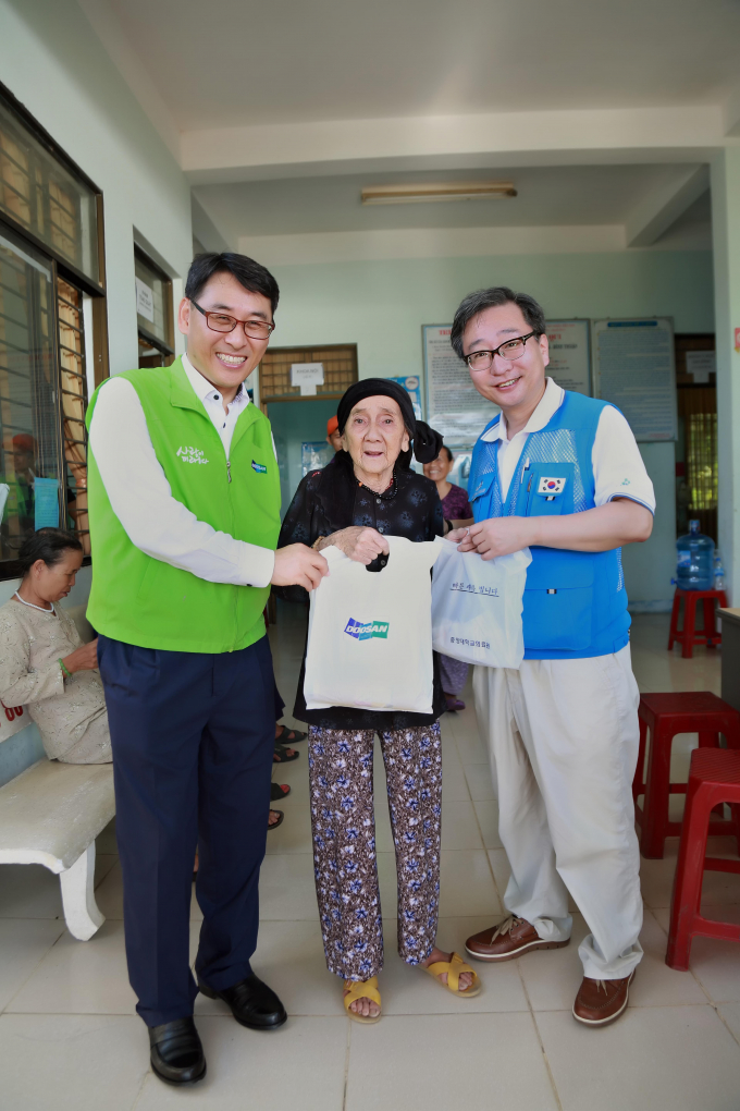 Tổng Gi&aacute;m đốc Doosan Vina Yeon In Jung (tr&aacute;i) v&agrave; &ocirc;ng Kwon Jeong Taik, Gi&aacute;o sư, b&aacute;c sĩ khoa Phẫu thuật thần kinh, bệnh viện Chung Ang (phải) trao thuốc v&agrave; qu&agrave; cho một người d&acirc;n.