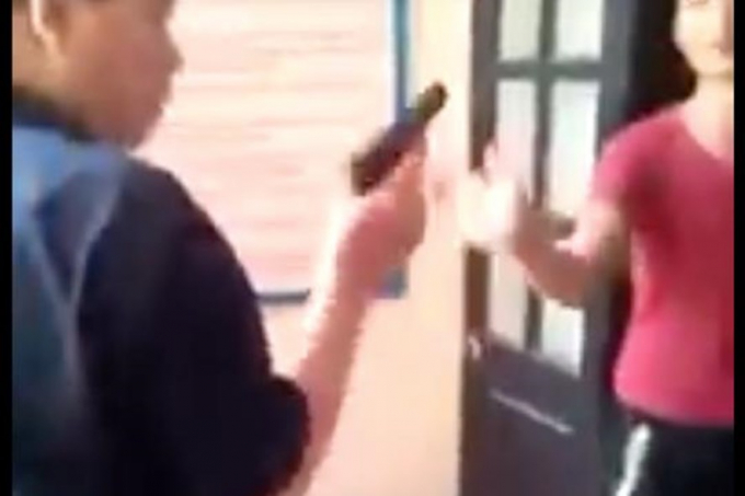 Người mặc &aacute;o đen được cho l&agrave; gi&aacute;m đốc Trung t&acirc;m ph&ograve;ng chống HIV/AIDS c&oacute; h&agrave;nh vi d&ugrave;ng s&uacute;ng dọa bắn bệnh nh&acirc;n. Ảnh cắt từ clip.