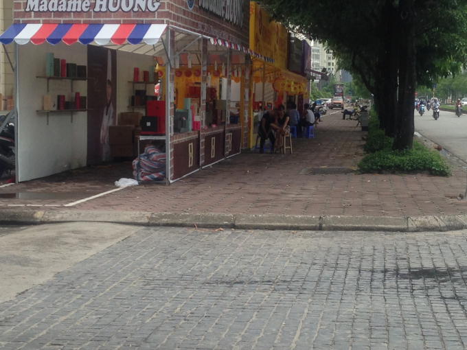Bị c&aacute;c gian h&agrave;ng chiếm dụng, nh&acirc;n vi&ecirc;n b&aacute;n h&agrave;ng ngồi cả ra ngo&agrave;i khiến cho vỉa h&egrave; tại đường Mễ Tr&igrave; hẹp đi tr&ocirc;ng thấy.